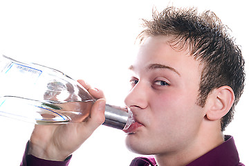 Image showing The young man drinks vodka from a bottle. Isolated