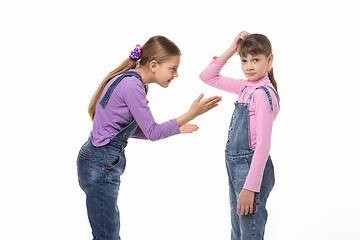 Image showing The girl is trying to explain something to her sister, she scratches her head in perplexity