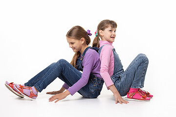 Image showing Children sitting on the floor pushing their backs
