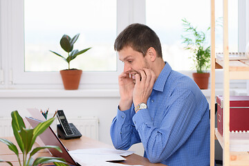 Image showing Office worker bites her nails while looking at the monitor screen