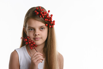 Image showing Portrait of a girl with a bunch of berries in her hair, as well as with a bunch in her hand