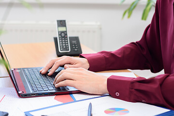 Image showing close-up of the hands of an office employee working on a laptop