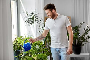 Image showing man watering houseplants at home