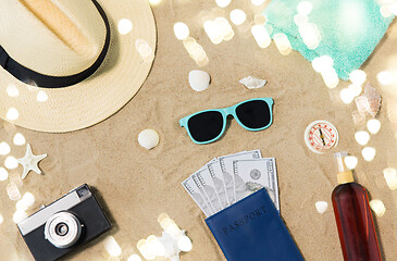 Image showing money in passport, shades and hat on beach sand