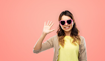 Image showing asian woman in heart-shaped sunglasses waving hand