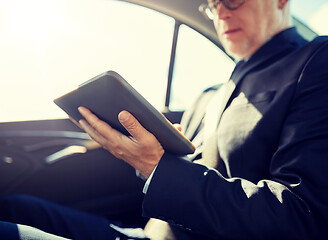 Image showing senior businessman with tablet pc driving in car