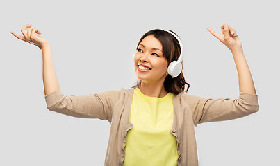 Image showing asian woman in headphones listening to music