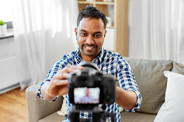 Image showing indian male video blogger adjusting camera at home