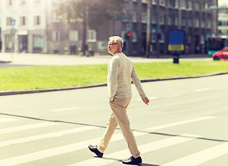 Image showing senior man walking along city crosswalk