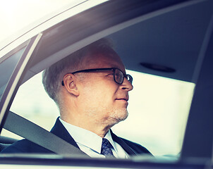 Image showing senior businessman driving on car back seat