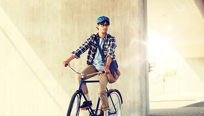 Image showing young hipster man with bag riding fixed gear bike