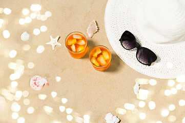 Image showing cocktails, sun hat and sunglasses on beach sand