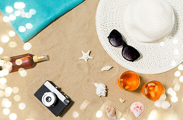 Image showing drinks, hat, camera and sunglasses on beach sand