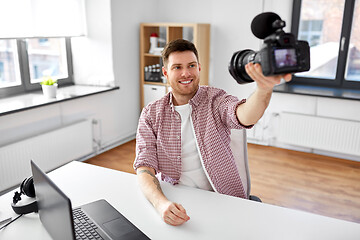 Image showing male blogger with camera videoblogging at office