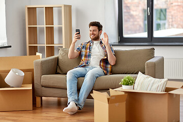 Image showing man with smartphone having video call at new home