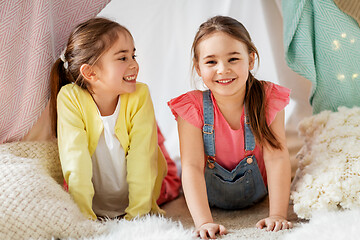 Image showing happy girls lying in kids tent at home