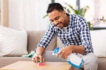 Image showing indian man cleaning table with detergent at home