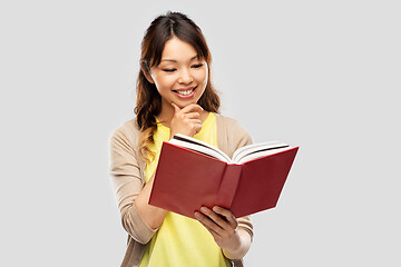 Image showing happy asian woman reading book