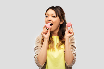 Image showing happy asian woman with macarons