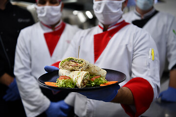 Image showing group chefs standing together in the kitchen at restaurant weari