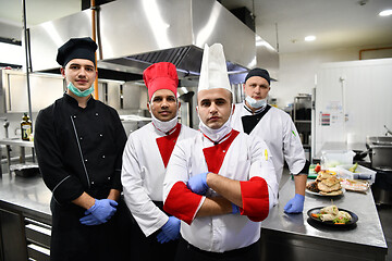 Image showing group chefs standing together in the kitchen at restaurant weari