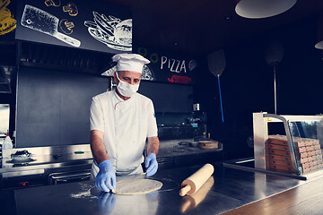 Image showing chef  with protective coronavirus face mask preparing pizza