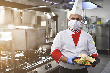 Image showing chef cook wearing face protective medical mask for protection fr