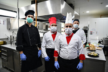 Image showing group chefs standing together in the kitchen at restaurant weari