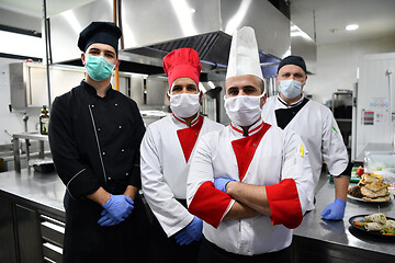 Image showing group chefs standing together in the kitchen at restaurant weari