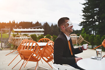 Image showing funny man in restaurant drinking coffee wearing face mask