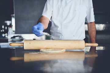 Image showing chef  with protective coronavirus face mask preparing pizza