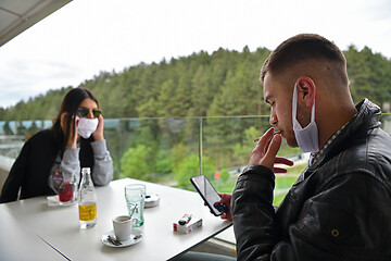 Image showing couple in restaurant wearing corona virus  medical protective fa