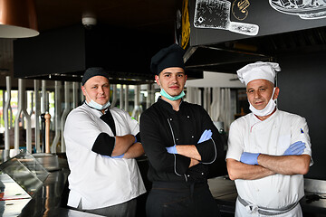 Image showing group chefs standing together in the kitchen at restaurant weari