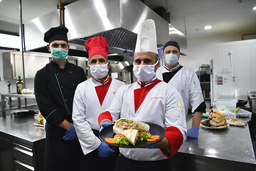 Image showing group chefs standing together in the kitchen at restaurant weari