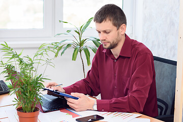 Image showing office employee works on a tablet in a light office