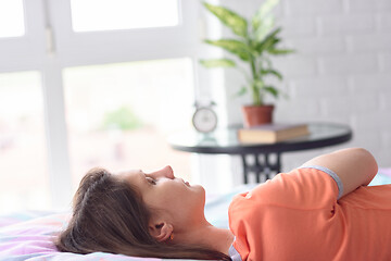 Image showing Girl sleeps in bed against the background of a window, close-up