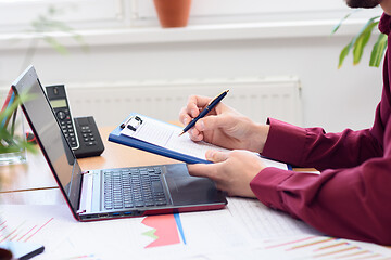 Image showing close-up of hands of men making notes in a notebook against the background of the desktop