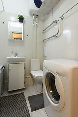 Image showing Classic small toilet with washing machine and washbasin