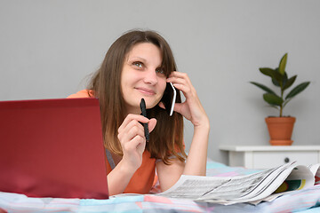 Image showing The girl calls up with employers by phone