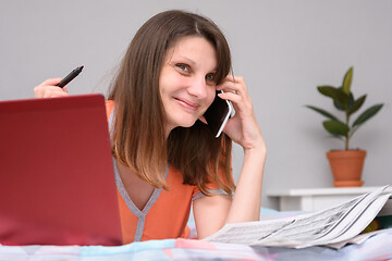 Image showing Unemployed girl calls up to employer on newspaper ads