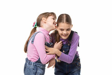 Image showing Girl bites her sisters ear having fun