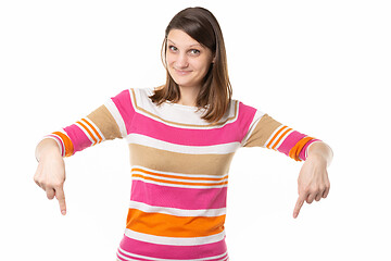 Image showing Girl with a charming smile points fingers down