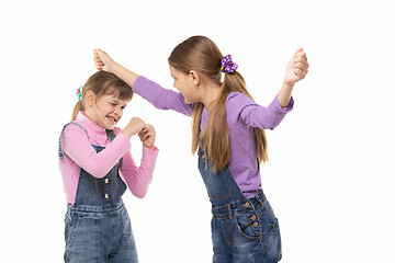 Image showing A girl beats another girl on the head