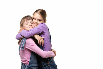 Image showing Two girlfriends happily hug each other, white background