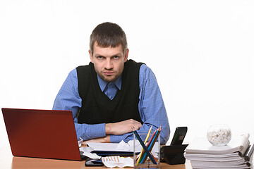 Image showing frownman sits at an office table on a white background