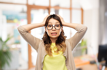 Image showing asian woman in glasses holding to head at office