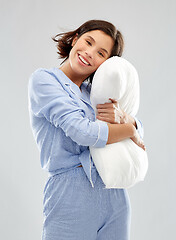 Image showing happy young woman in pajama hugging pillow