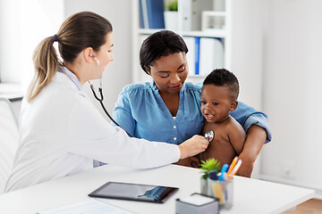 Image showing doctor with stethoscope listening baby at clinic