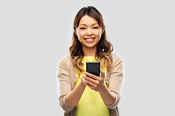 Image showing happy asian woman using smartphone