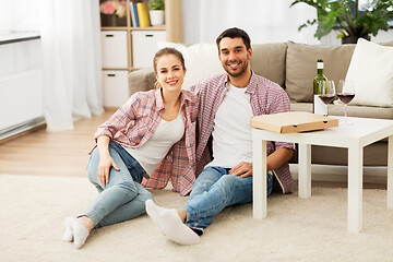 Image showing happy couple with wine and takeaway pizza at home